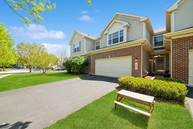 view of front of house with brick siding, an attached garage, driveway, and a front lawn