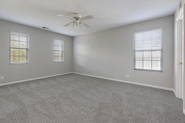 carpeted empty room featuring a ceiling fan and baseboards