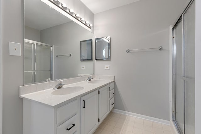 full bath featuring a shower stall, double vanity, baseboards, and tile patterned flooring