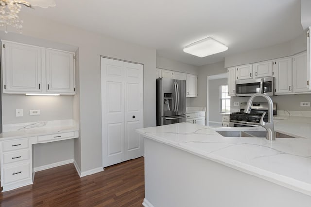 kitchen featuring stainless steel appliances, dark wood-style floors, light stone countertops, and white cabinets