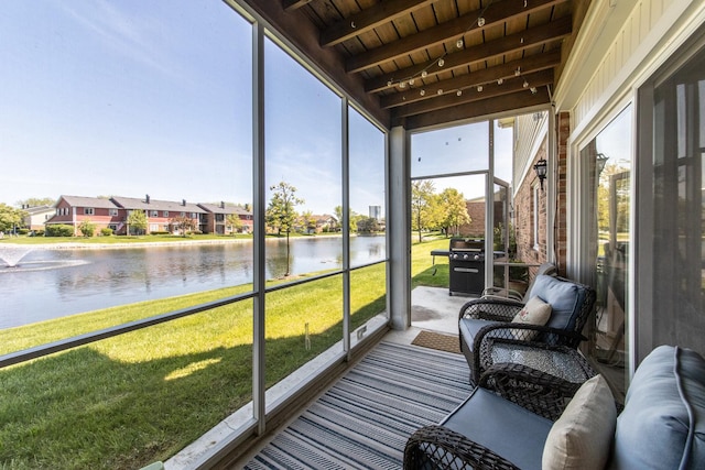 sunroom with a water view, beam ceiling, and a residential view