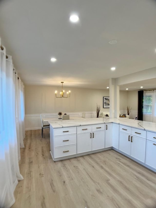 2508 Mitchell Dr, Woodridge, IL 60517 - kitchen with a peninsula, light stone counters, white cabinetry, light wood-type flooring, and recessed lighting
