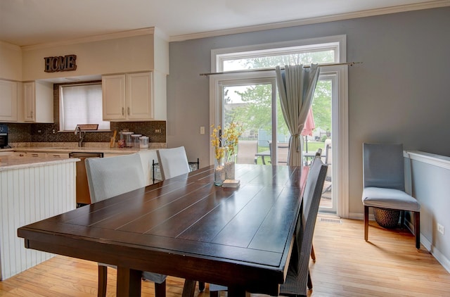 dining room featuring light wood-type flooring and ornamental molding