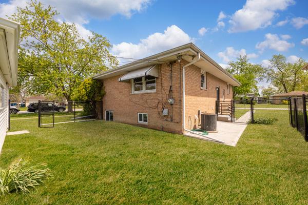 15100 Hamlin Ave, Midlothian, IL 60445 - view of property exterior featuring brick siding, central AC unit, and a gate
