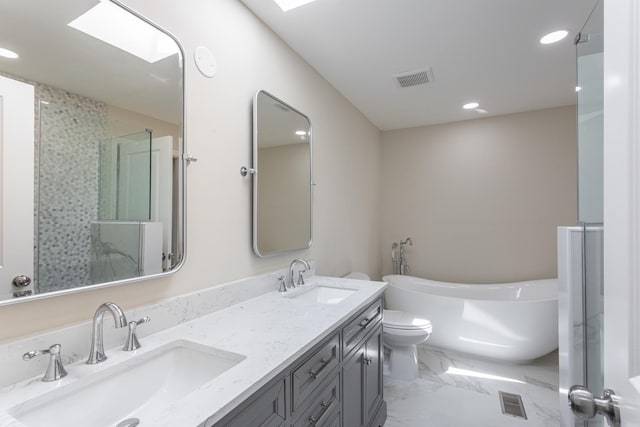 bathroom featuring recessed lighting, a soaking tub, marble finish flooring, double vanity, and toilet
