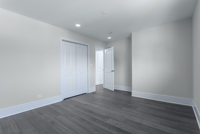 unfurnished bedroom with dark wood finished floors, recessed lighting, baseboards, and a closet