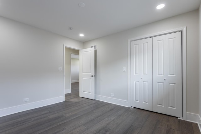 unfurnished bedroom featuring dark wood-style flooring, recessed lighting, baseboards, and a closet