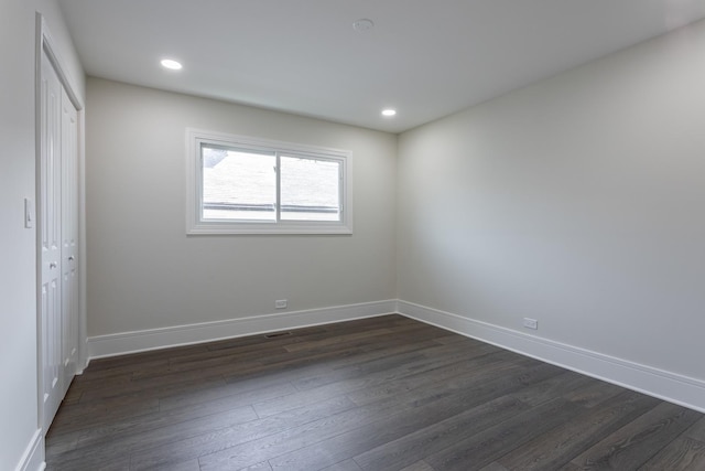 unfurnished bedroom with dark wood-style floors, a closet, baseboards, and recessed lighting