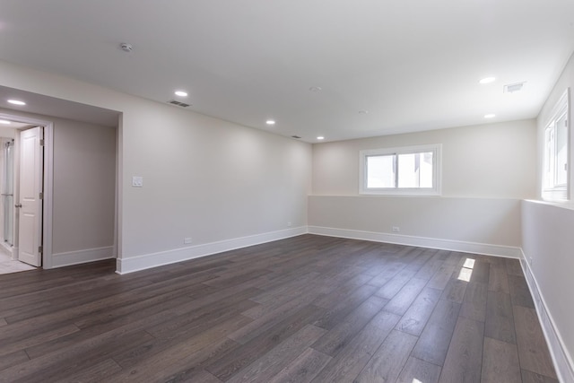 basement with dark wood-type flooring, baseboards, and recessed lighting