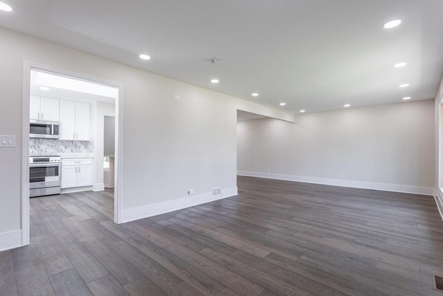 spare room with dark wood-style floors, baseboards, and recessed lighting