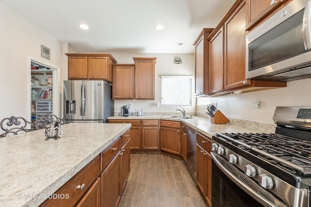 3313 Christopher Ln, Johnsburg, IL 60051 - kitchen featuring stainless steel appliances, brown cabinetry, a sink, dark wood-style floors, and recessed lighting