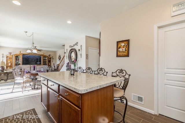 3313 Christopher Ln, Johnsburg, IL 60051 - kitchen with a kitchen bar, light countertops, dark wood finished floors, a center island, and baseboards