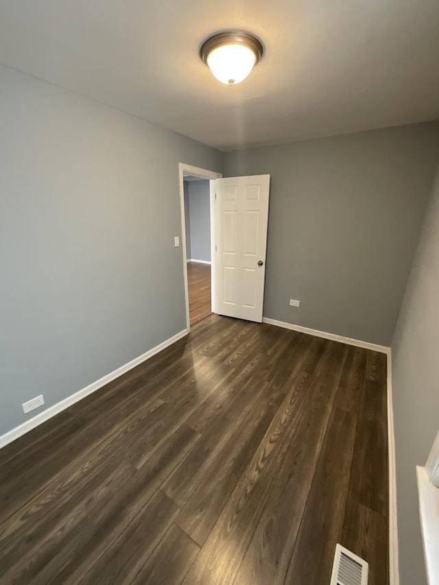 6954 S Prairie Ave, Chicago, IL 60637 - empty room featuring dark wood-type flooring and baseboards