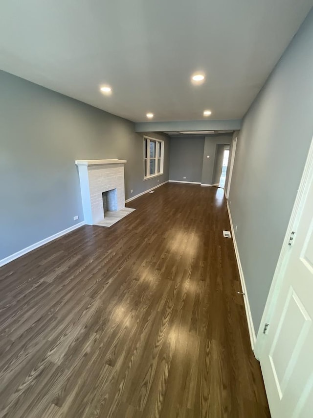 6954 S Prairie Ave, Chicago, IL 60637 - unfurnished living room featuring baseboards, dark wood-style floors, recessed lighting, and a brick fireplace