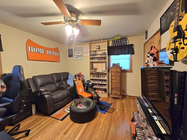 living area with a ceiling fan and wood finished floors