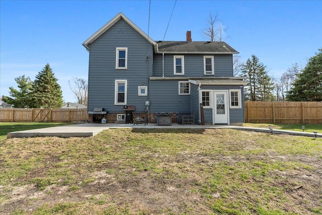 back of house with a patio area and a chimney
