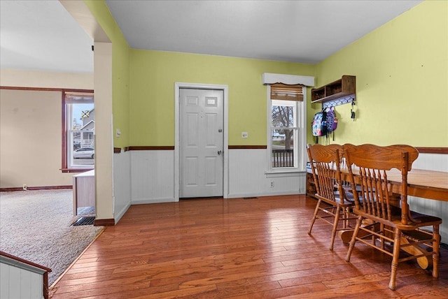 dining area with a wainscoted wall and hardwood / wood-style flooring