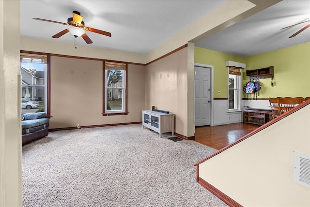 unfurnished living room featuring ceiling fan, carpet flooring, and baseboards