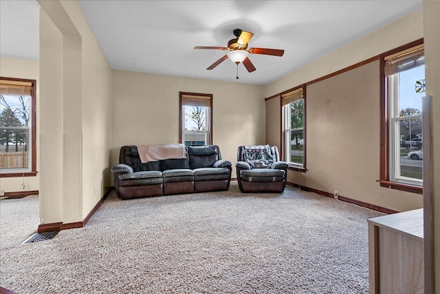 living room featuring carpet floors, ceiling fan, and baseboards