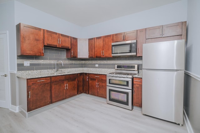 5631 S Throop St, Chicago, IL 60636 - kitchen featuring appliances with stainless steel finishes, a sink, light wood finished floors, and tasteful backsplash