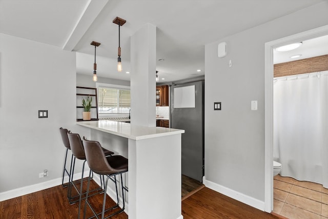 11026 S S Ave H, Chicago, IL 60617 - kitchen with a peninsula, a kitchen bar, baseboards, light countertops, and recessed lighting