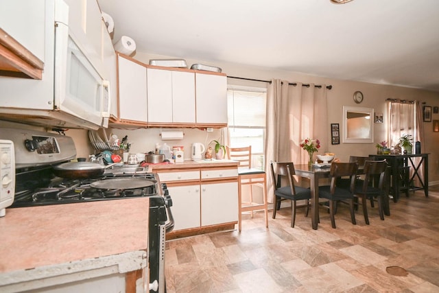 1423 Victoria Ave, North Chicago, IL 60064 - kitchen featuring stainless steel gas range oven, light countertops, white cabinets, and white microwave
