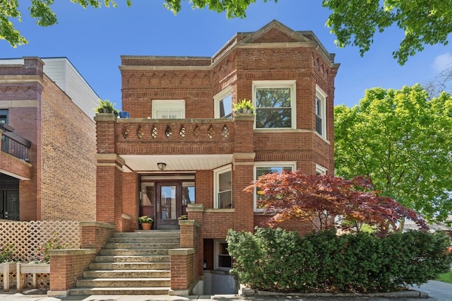 view of front of house featuring brick siding, a balcony, and a porch