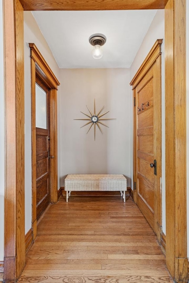 hall featuring light wood finished floors and baseboards