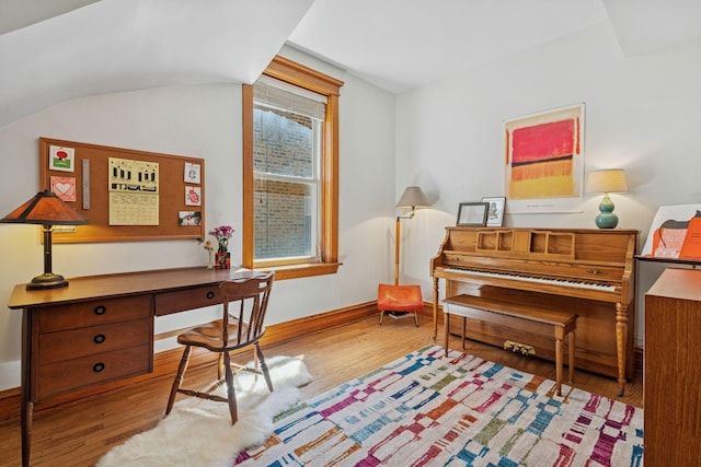 home office featuring wood finished floors, baseboards, and lofted ceiling