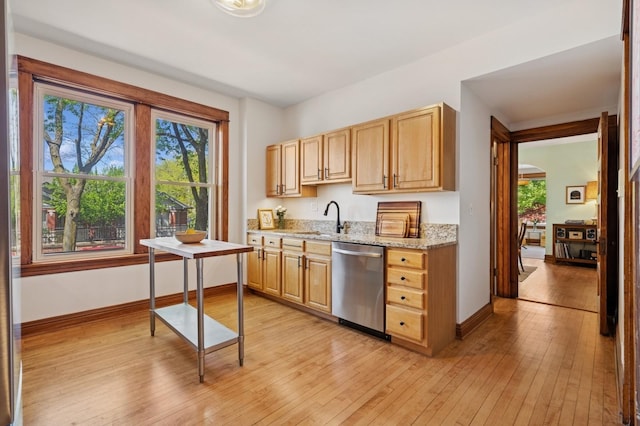 kitchen featuring dishwasher, a sink, baseboards, and light wood-style floors