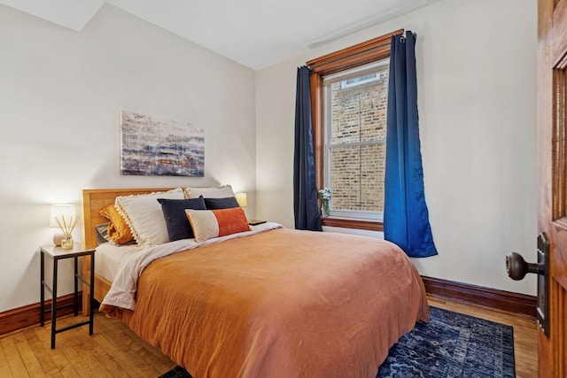 bedroom with baseboards and hardwood / wood-style floors