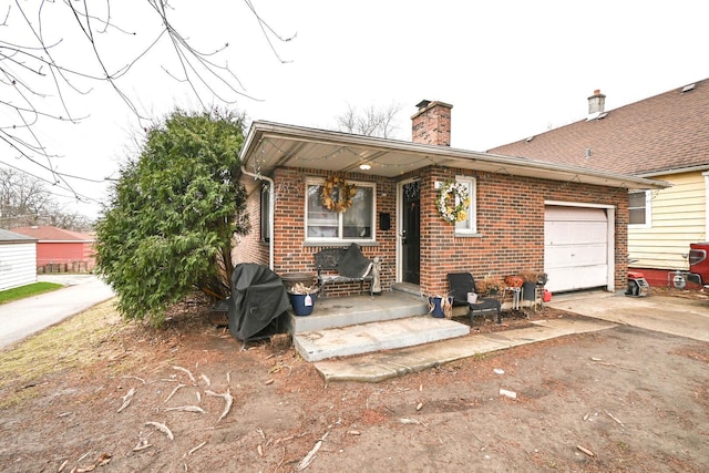 1911 Elizabeth Ave, North Chicago, IL 60064 - view of front of home with brick siding, an attached garage, a chimney, and concrete driveway