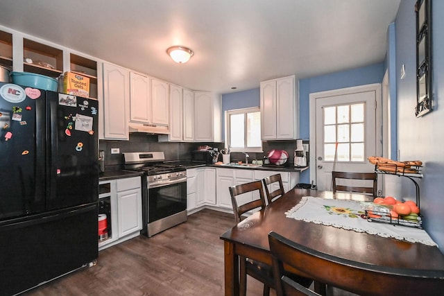 1911 Elizabeth Ave, North Chicago, IL 60064 - kitchen with freestanding refrigerator, stainless steel range with gas cooktop, under cabinet range hood, a sink, and dark countertops