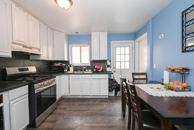 1911 Elizabeth Ave, North Chicago, IL 60064 - kitchen with under cabinet range hood, stainless steel gas range, dark countertops, white cabinets, and dark wood-style flooring