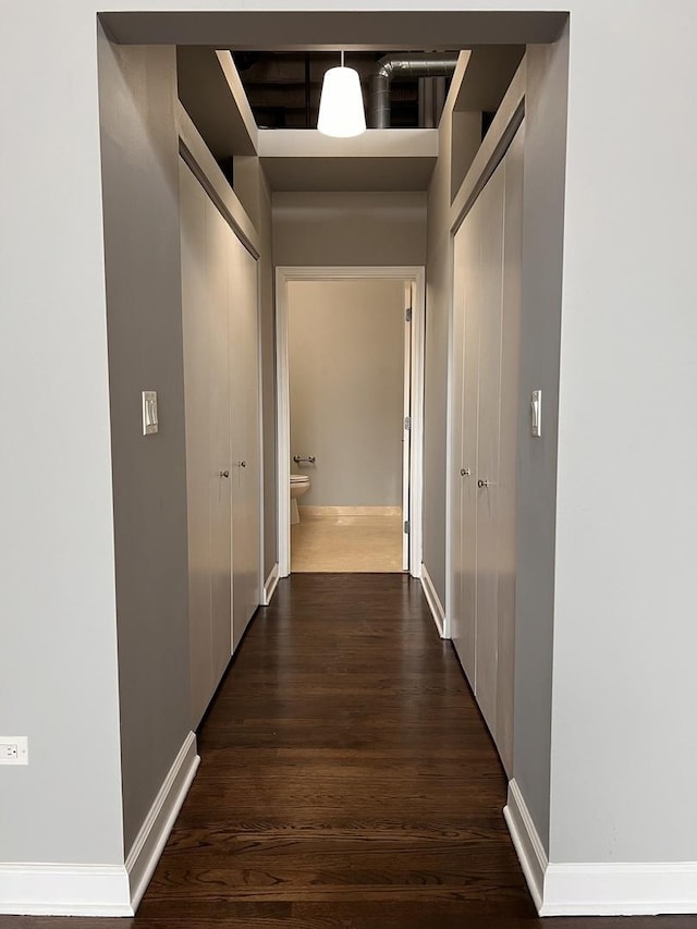 hallway with wood finished floors and baseboards