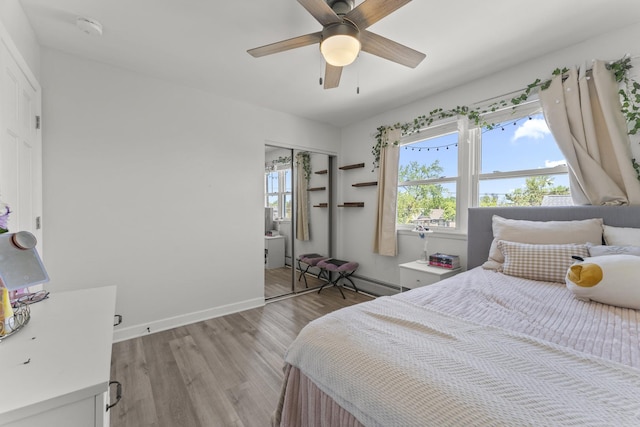 bedroom with light wood-style flooring, baseboards, a ceiling fan, and a closet