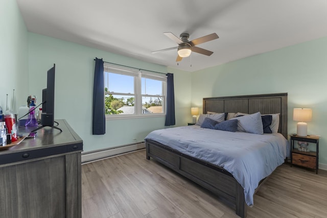 bedroom featuring a baseboard radiator, light wood-style flooring, baseboards, and ceiling fan