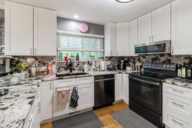 772 Red Oak Dr, Bartlett, IL 60103 - kitchen featuring dishwashing machine, black range with electric cooktop, stainless steel microwave, a sink, and decorative backsplash