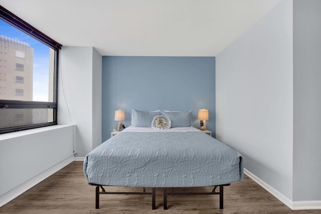 bedroom featuring wood finished floors and baseboards