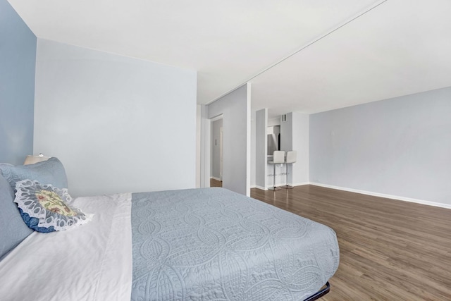 bedroom with wood finished floors and baseboards
