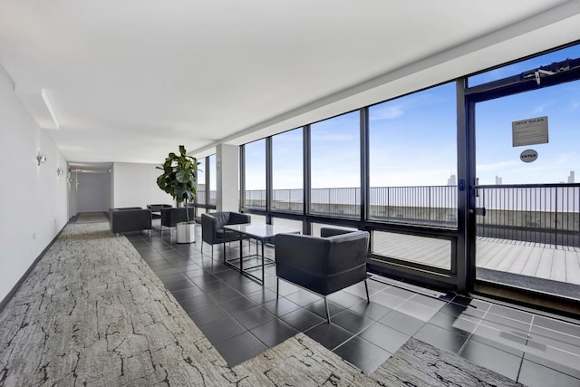 living area featuring expansive windows, a water view, and baseboards