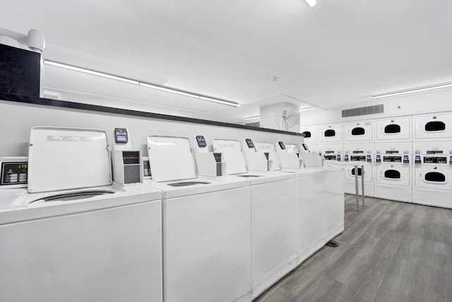 community laundry room with washer and dryer, light wood finished floors, and stacked washer / drying machine