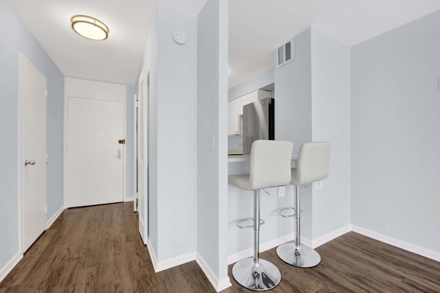 hallway featuring dark wood finished floors and baseboards