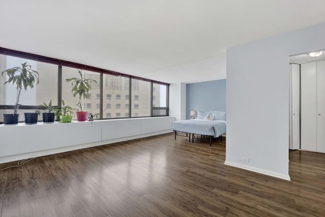 bedroom featuring wood finished floors and baseboards