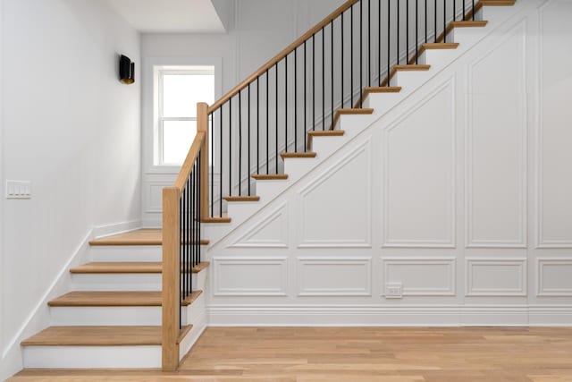 staircase featuring wood finished floors and baseboards