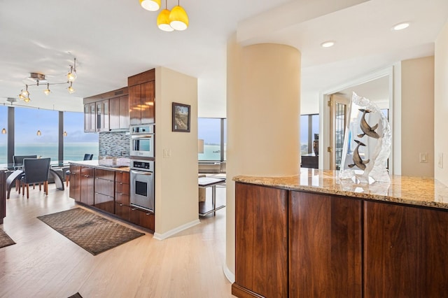505 N Lake Shore Dr Unit 4907, Chicago, IL 60611 - kitchen with light wood finished floors, modern cabinets, backsplash, and light stone counters