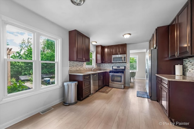 9 N Walnut Ct, Streamwood, IL 60107 - kitchen featuring appliances with stainless steel finishes, a sink, decorative backsplash, and light wood-style flooring