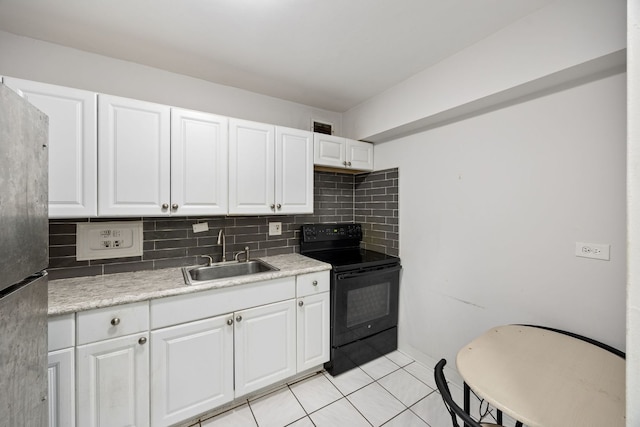 7337 S S Shore Dr Unit 1227, Chicago, IL 60649 - kitchen with black range with electric cooktop, a sink, freestanding refrigerator, light tile patterned floors, and light countertops