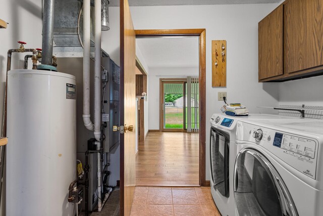 849 N Piatt St, Bement, IL 61813 - laundry room featuring cabinet space, water heater, washer and dryer, and light tile patterned floors