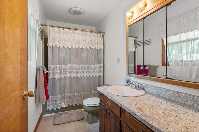 849 N Piatt St, Bement, IL 61813 - bathroom featuring vanity, toilet, tile patterned floors, and a shower with shower curtain